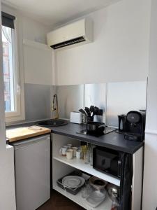a small kitchen with a black counter top at Studio hyper centre in Marseille
