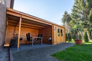 a wooden cabin with a table and chairs on a patio at Ferienwohnung Leipzig- Hirschfeld Apartments in Leipzig