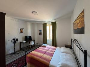 a bedroom with a bed and a desk and a window at La Funtanella in Aggius