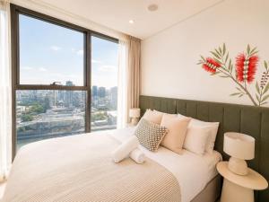 a bedroom with a large bed with a large window at Koala Sky Suite River & City Views in Brisbane