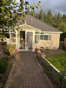 a house with a brick walkway leading to the front door at 4 Glenfalloch Road in Crianlarich
