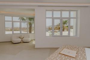 a bedroom with white walls and a large window at Kallos of Mykonos in Ornos +82 photos
