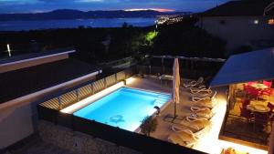 a swimming pool on the roof of a house at night at Apartman Kata in Šmrika