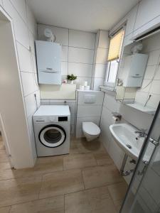 a small bathroom with a washing machine and a sink at Ferienwohnung Trinh in Überlingen +11 photos