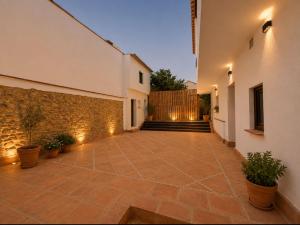 a courtyard with potted plants and a stone wall at Apartamento Torre in Cártama