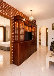 a living room with a tv and a brick wall at Villa Murataj in Ksamil