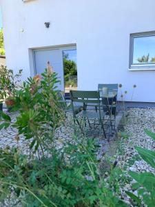 a patio with a table and chairs in front of a house at Joe's Home Naumburg -modern,vintage Apartment in Naumburg