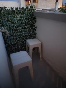 a room with two stools and a green wall at La RIVISTA in Manduria