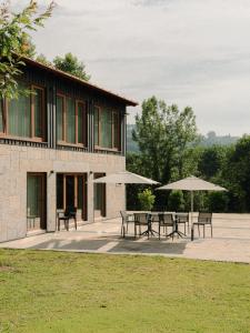 a group of tables and umbrellas in front of a building at Constance Retreat - Douro Verde by FERO in Constance