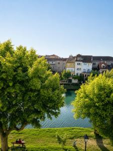 two people sitting on a park bench next to a lake at Hotel Santa Clara in Monforte de Lemos