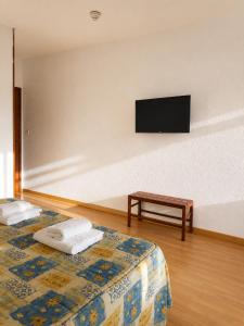 a hotel room with two beds and a flat screen tv at Hotel Santa Clara in Monforte de Lemos