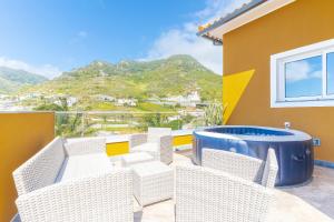 a balcony with wicker chairs and a view of a mountain at Recanto do Sol by Atlantic Holiday in Caniçal