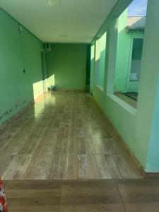 an empty room with green walls and a wooden floor at Flat mobiliado centro formosa Go in Formosa