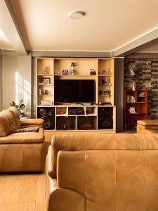 a living room with a couch and a flat screen tv at Ayllu in Huaraz