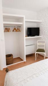 a bedroom with a bed and a chair and a tv at Est 1852 Andros - Tower 2 in Lámira
