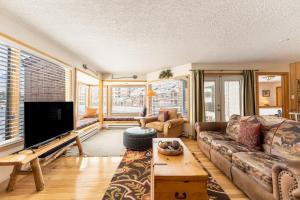 a living room with a couch and a flat screen tv at Willows #1704 in Keystone +36 photos