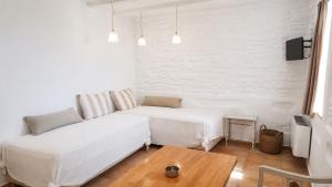 a living room with two beds and a table at Est 1852 Andros - Tower 2 in Lámira