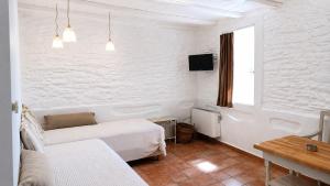 a white room with a bed and a table at Est 1852 Andros - Tower 2 in Lámira +12 photos