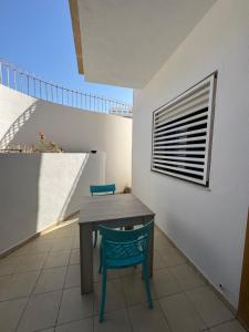 a table and a blue chair on a balcony at Pearl Beach Apartment in Monastir +5 photos