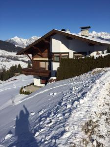 a shadow of a person in the snow in front of a house at Ferienwohnung Prantner in Sellrain +12 photos