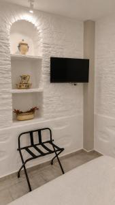 a bedroom with a tv on a white wall at Est 1852 Andros - Tower 1 in Lámira