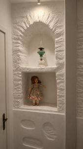 a doll sitting on a shelf in a white wall at Est 1852 Andros - Tower 1 in Lámira