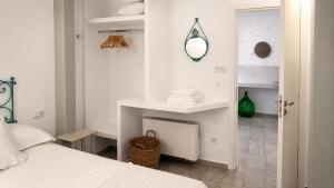 a white bedroom with a bed and a mirror at Est 1852 Andros - Tower 1 in Lámira +23 photos