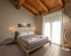 a bedroom with a large bed and a large window at Radici in Serralunga d'Alba +29 photos