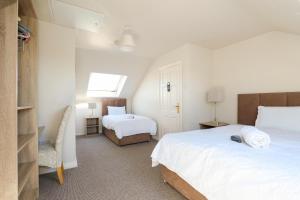 a bedroom with two beds and a chair in it at Almara Guesthouse in Galway
