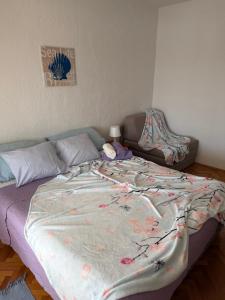 a bed with a blanket on it in a bedroom at Apartman Kata in Šmrika +16 photos