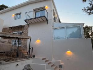 a white house with stairs and a balcony at Villa Alicante Beach in El Campello