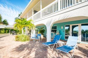 a patio with blue chairs and a house at Escape Coastal Resort on Casey Key in Nokomis