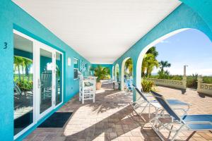 a blue house with chairs on a patio at Escape Coastal Resort on Casey Key in Nokomis