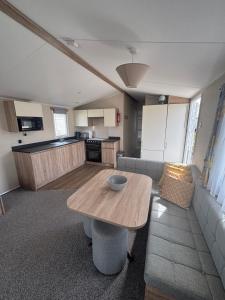 a living room with a table and a kitchen at Seaview Holiday Rentals - Etchingham in Chestfield