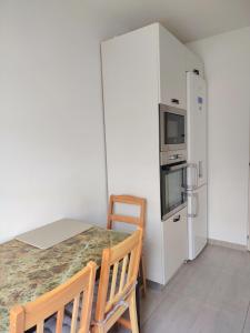 a kitchen with a table and a refrigerator at Adrian Home, Central in Ploieşti +7 photos