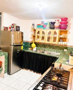 a kitchen with a stainless steel refrigerator and a sink at Hostal El Viajero-Mindo in Mindo
