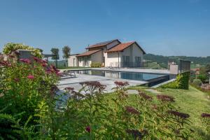 a villa with a swimming pool in a garden at Radici in Serralunga d'Alba