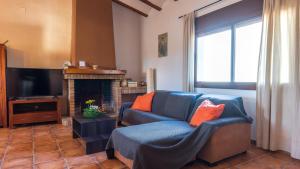 a living room with a blue couch and a fireplace at Casa Rue in Deltebre
