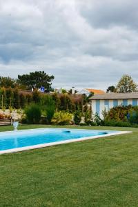 a swimming pool in the middle of a yard at Villa Lottus in Carvalhal