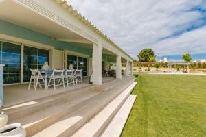 a porch of a house with a table and chairs at Villa Lottus in Carvalhal