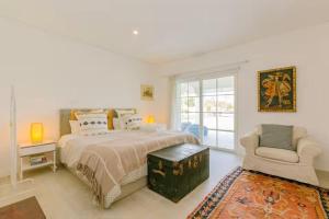 a white bedroom with a bed and a chair at Villa Lottus in Carvalhal +62 photos