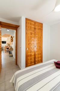a bedroom with a bed with a wooden door at Apartament in Monte Pedreguer in Pedreguer +14 photos