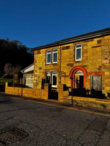 a brick building with a red door on a street at Hamilton House Guest House in Oban