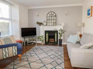 a living room with a couch and a fireplace at Tin Lantern Cottage in Redruth