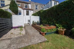 a garden with two raised beds of plants at Tin Lantern Cottage in Redruth