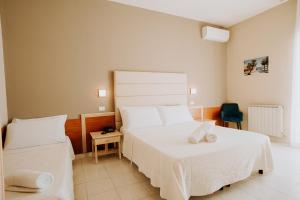 a bedroom with two beds and a chair at Hotel Holiday in Vasto +33 photos