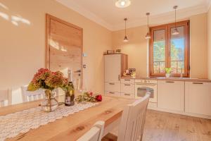 a kitchen with a wooden table with flowers in a vase at Vila Trate with Shared Pool and Garden in Ljutomer