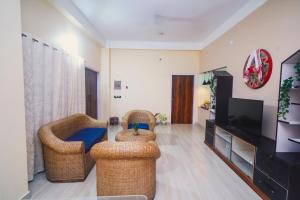a living room with two chairs and a flat screen tv at Mong Mao Manor in Guwahati