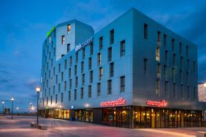 a rendering of the guggenheim hotel at night at Ibis Budget Mulhouse Centre Gare in Mulhouse