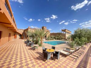 a resort with a pool and chairs and a patio at Auberge Famille Benmoro in Skoura +121 photos